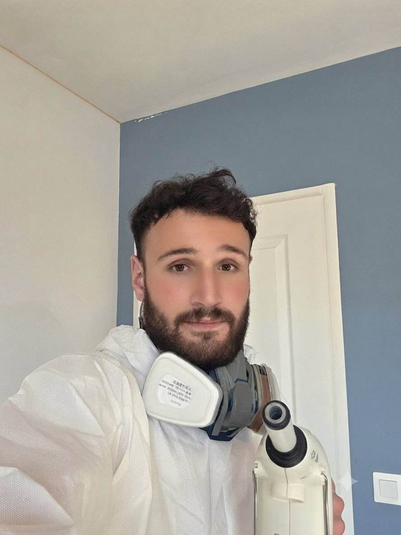 Technicien en tenue de protection intégrale préparant le traitement vapeur sèche contre les punaises de lit